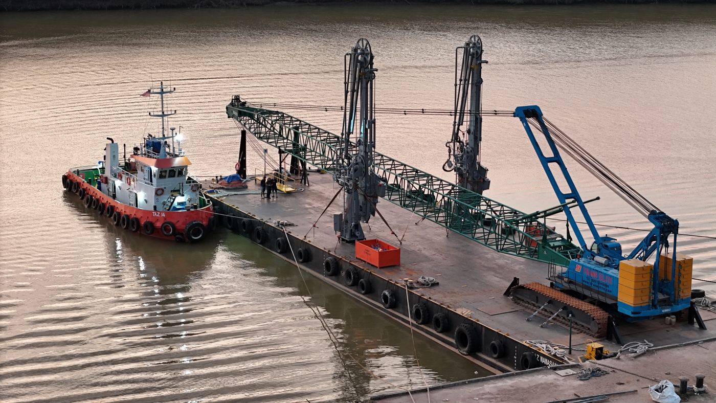Crane barge and tug at dusk